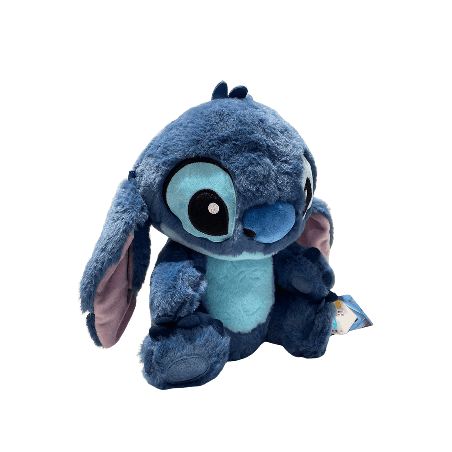 Peluche Stitch bleue en tissu doux et poilu, avec ventre turquoise, grandes oreilles roses et yeux brodés.