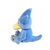 Peluche Akwakwak bleue en tissu doux, au bec jaune et aux griffes jaunes, assise avec une longue queue