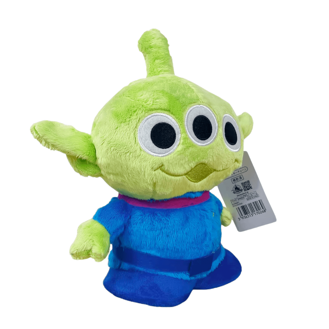 peluche Alien verte en tissu doux, avec trois grands yeux noirs cerclés de blanc et une combinaison bleue