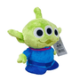 peluche Alien verte en tissu doux, avec trois grands yeux noirs cerclés de blanc et une combinaison bleue