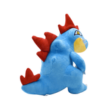 Peluche Aligatueur bleue en tissu doux, ornée de nageoires rouges, d’un museau jaune et d’un œil brodé.