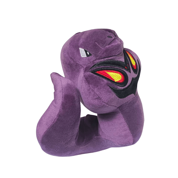 Peluche Arbok violette en tissu doux, avec un motif facial noir, rouge et jaune brodé sur le ventre.