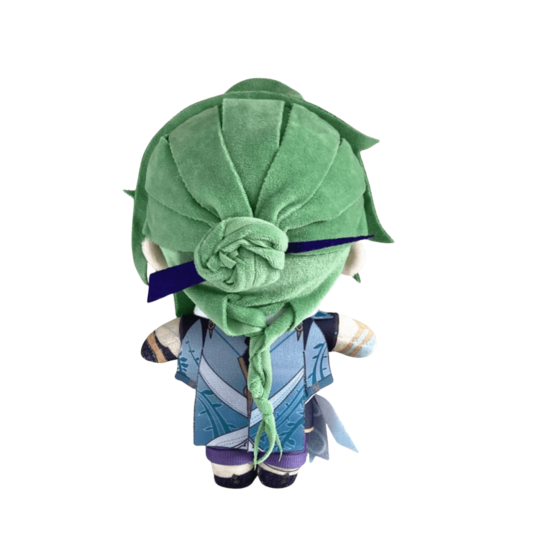 Peluche Baizhu aux cheveux verts et tressés, vêtue d’une tunique bleue à motifs et d’un bandeau violet.