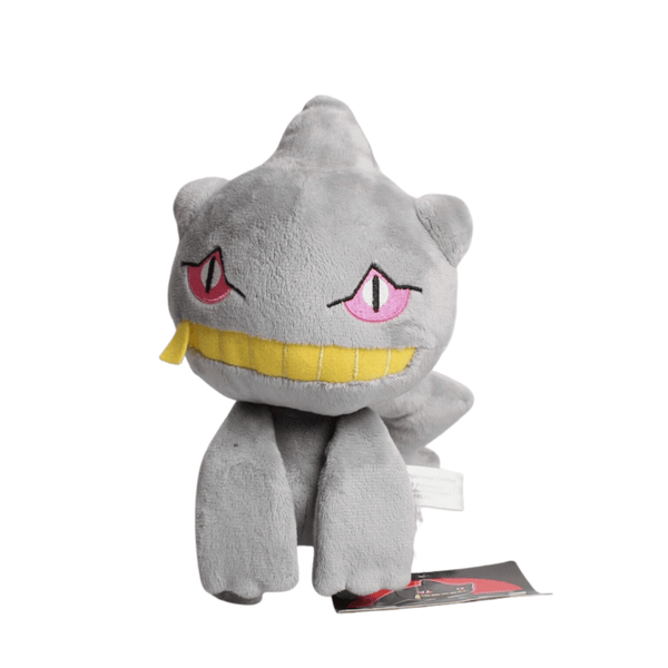Peluche Branette grise en tissu doux, avec des yeux roses et rouges, une large bouche jaune et trois pointes sur la tête.
