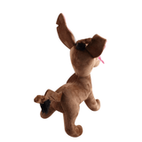 Peluche Dante représentant un chien brun en tissu doux, aux grandes oreilles dressées, avec une langue rose apparente.