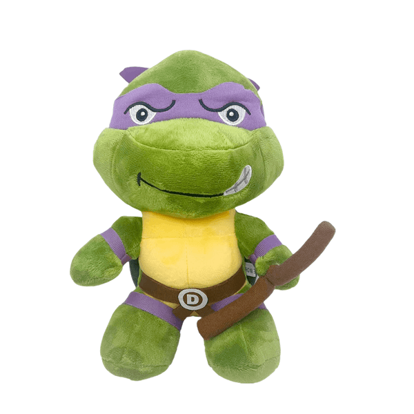 Peluche Donatello verte en tissu doux, avec bandeau violet, plastron jaune et bâton brun tenu devant lui.