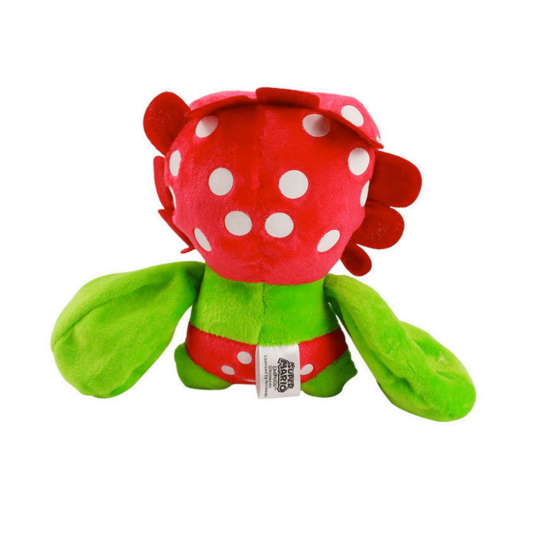 Peluche Flora Piranha rouge et verte, avec une tête à pois blancs, des pétales et de grandes feuilles en guise de bras.