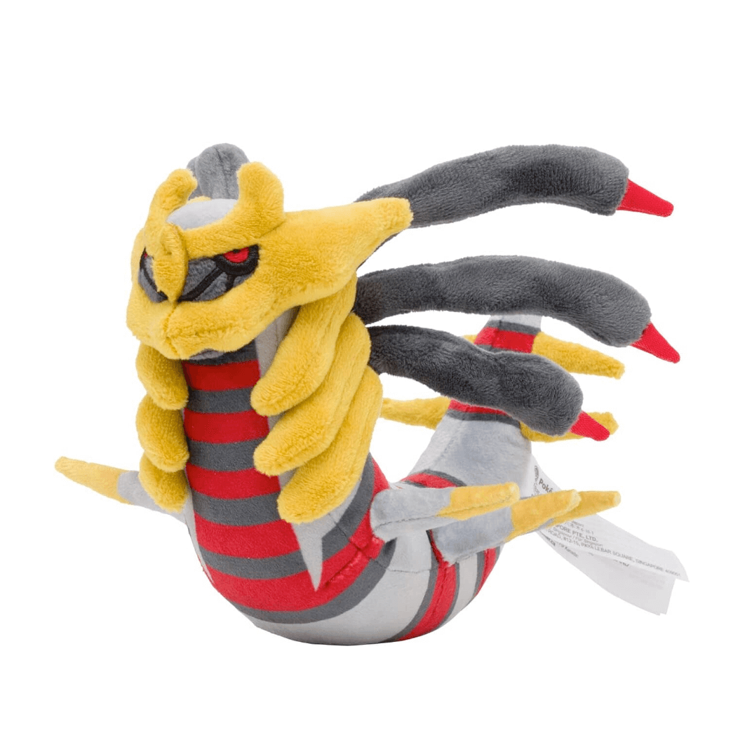 Peluche Giratina jaune, grise et rouge, avec plusieurs longues extensions dorsales et des yeux rouges brodés.