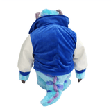 Peluche peluche Jacques Sullivan bleue et turquoise, vêtue d’un sweat à capuche bleu avec une longue queue mauve