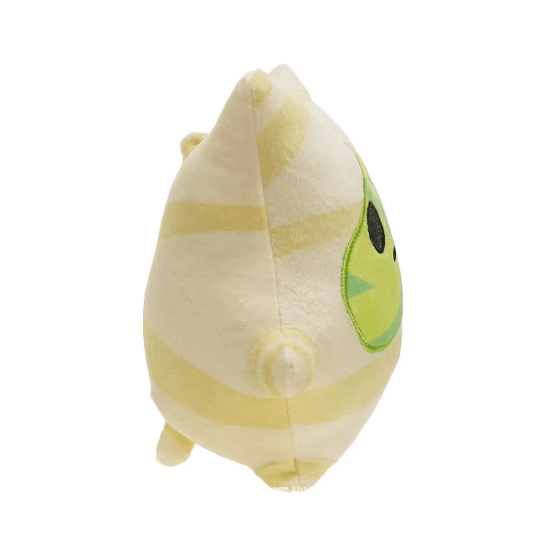 peluche Korogu en tissu beige et jaune pâle, avec une grande feuille verte brodée en guise de visage