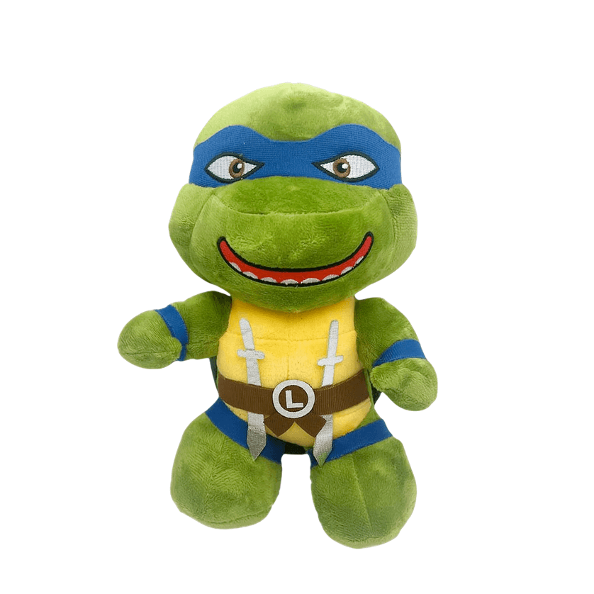 Peluche Leonardo verte en tissu doux, avec masque bleu, plastron jaune, ceinture brune et sourire brodé.