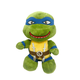 Peluche Leonardo verte en tissu doux, avec masque bleu, plastron jaune, ceinture brune et sourire brodé.