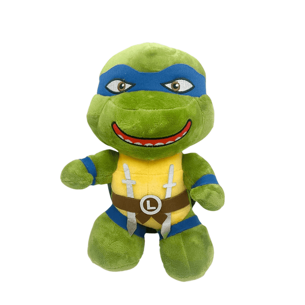 Peluche Leonardo verte en tissu doux, avec masque bleu, plastron jaune, ceinture brune et sourire brodé.