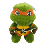 Peluche Michelangelo verte en tissu doux, avec masque orange, carapace jaune et marron et nunchaku blanc