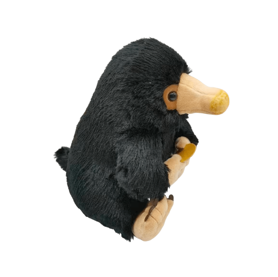 Peluche Niffleur noire à poils doux, avec un long bec beige, des pattes claires et un objet doré dans les mains.