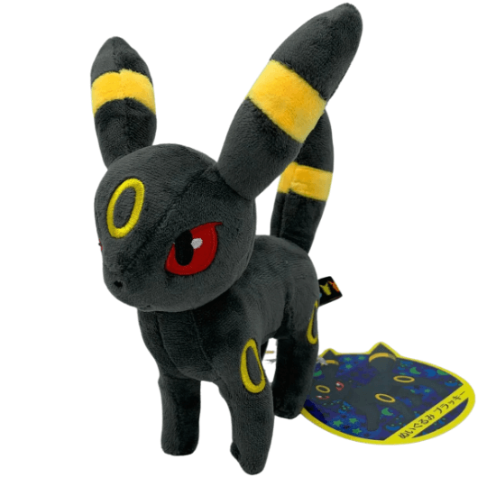 Peluche Noctali noire en tissu doux, avec des anneaux jaunes, des oreilles rayées et des yeux rouges.