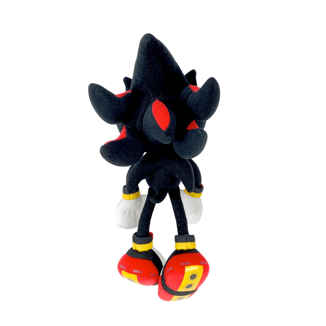 Peluche Shadow en tissu noir, avec des détails rouges, des gants blancs et de grandes chaussures rouges et jaunes.