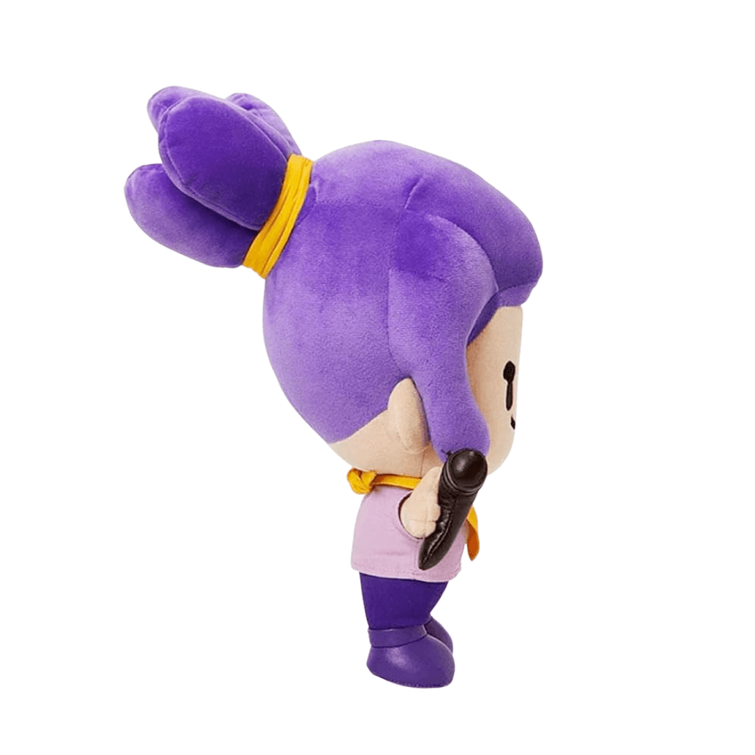 peluche Shelly violette aux cheveux attachés d’un ruban jaune, vêtue de mauve et tenant un fusil noir