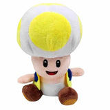 Peluche Toad au toucher doux, coiffé d’un grand chapeau blanc à pois jaune, avec gilet jaune et chaussures brunes.