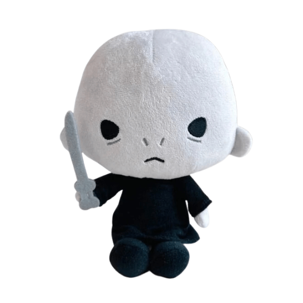 Peluche Voldemort à la peau blanche et à la robe noire, avec un visage brodé et une baguette grise en main.