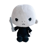 Peluche Voldemort à la peau blanche et à la robe noire, avec un visage brodé et une baguette grise en main.