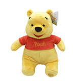 Peluche Winnie jaune en tissu doux, vêtue d’un tee-shirt rouge marqué « Pooh », avec un sourire brodé.