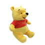 Peluche Winnie jaune en tissu doux, habillée d’un tee-shirt rouge avec l’inscription « Pooh » et un nez noir