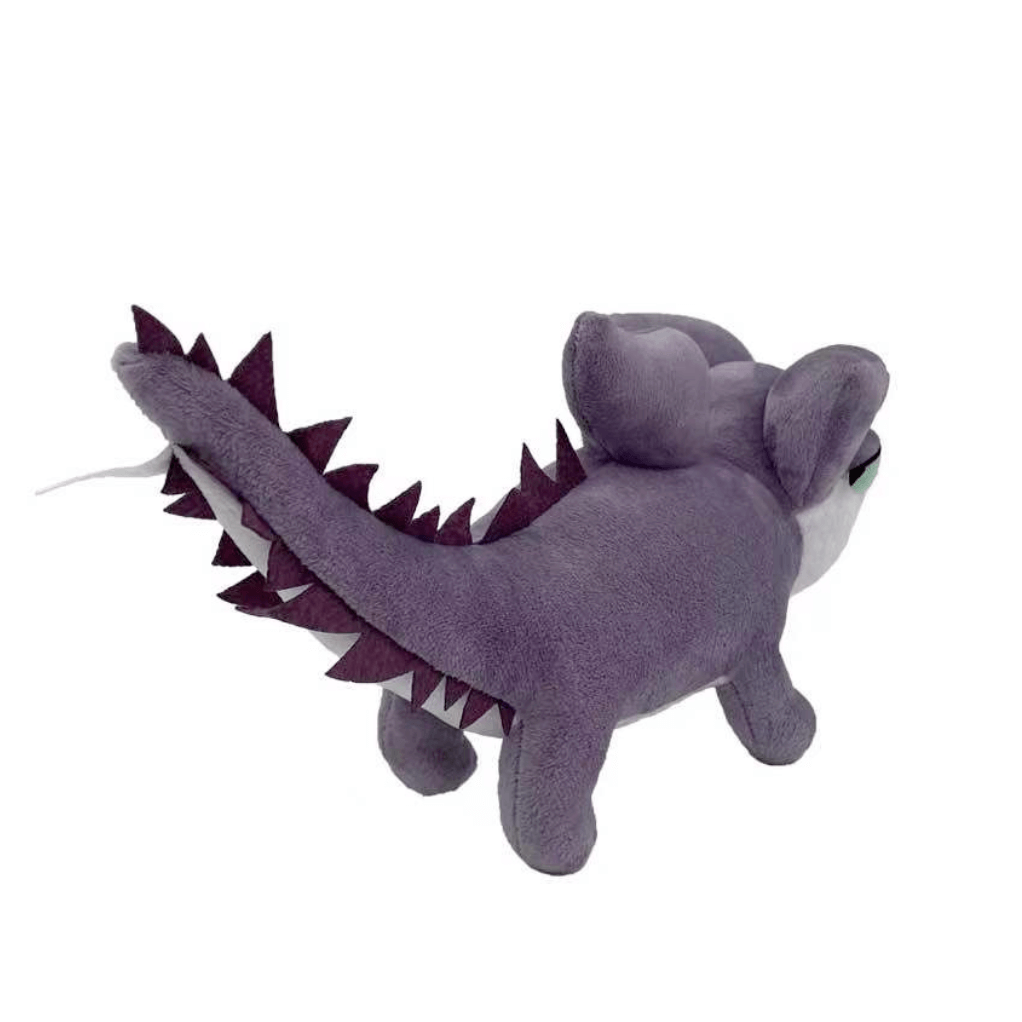 Peluche Zoé en forme de lézard violet, au toucher doux, avec de grandes oreilles et une longue queue bordée de pointes sombres.